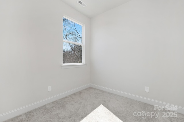 unfurnished room featuring baseboards, visible vents, and light colored carpet