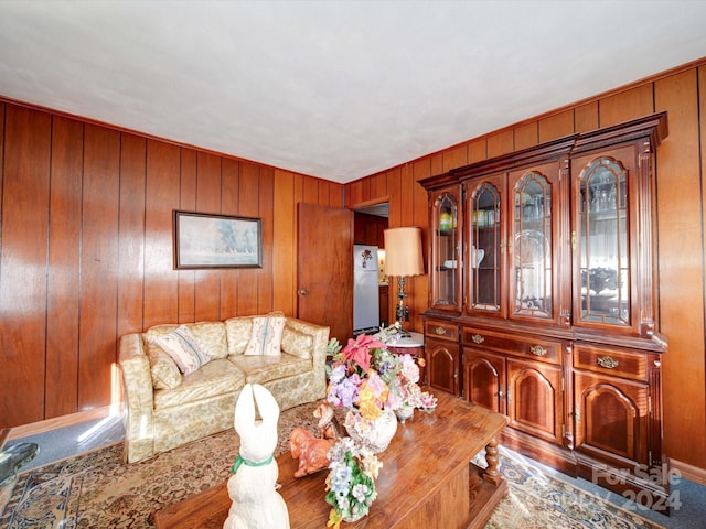 living room featuring carpet flooring and wood walls