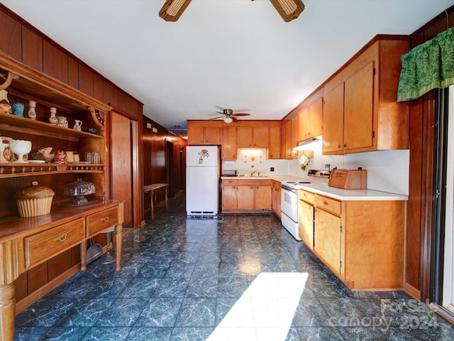 kitchen with white appliances, ceiling fan, wooden walls, and sink