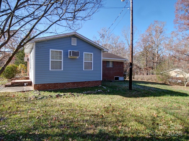 view of property exterior with an AC wall unit and a lawn