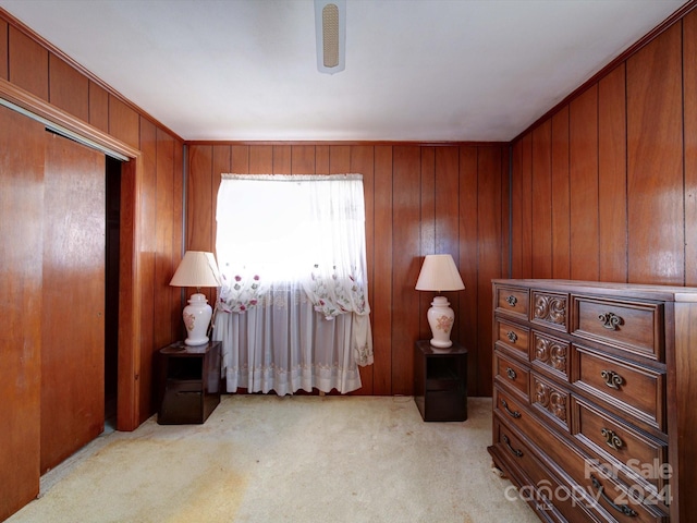 carpeted bedroom with wood walls