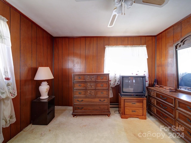 carpeted bedroom with wooden walls and ceiling fan