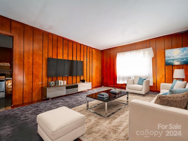 carpeted living room with wooden walls