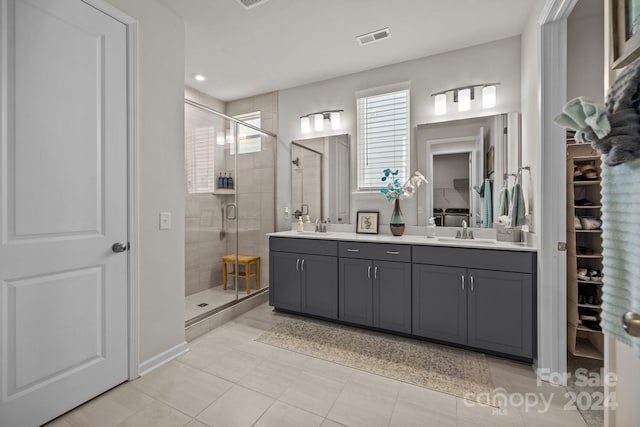 bathroom featuring tile patterned flooring, vanity, and a shower with door