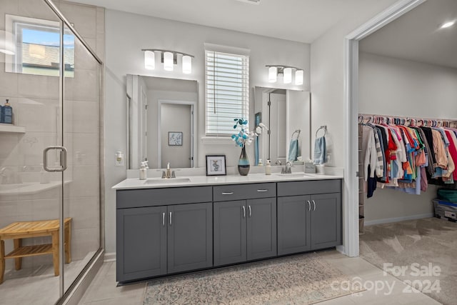 bathroom with vanity, walk in shower, a healthy amount of sunlight, and tile patterned floors