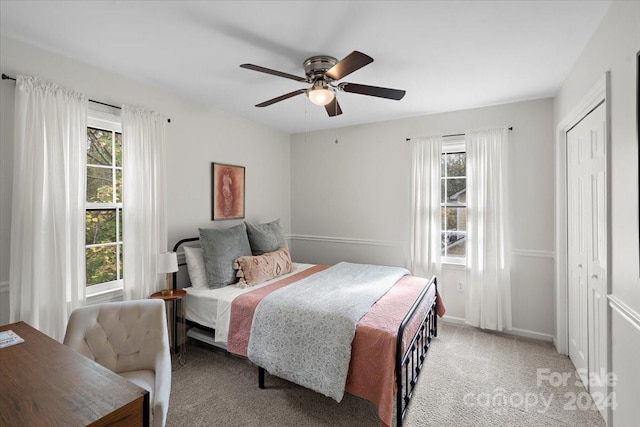 carpeted bedroom with ceiling fan and a closet