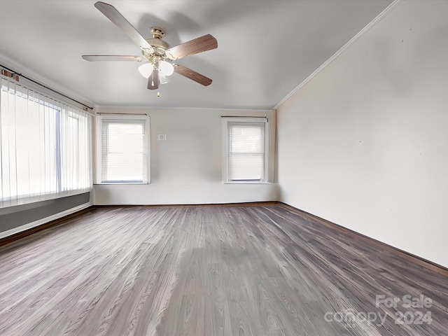 spare room featuring ornamental molding, hardwood / wood-style flooring, ceiling fan, and plenty of natural light