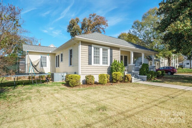 402 W 7th St, Newton, NC 28658 - view of front of home with a trampoline, a front lawn, covered porch, and a shingled roof