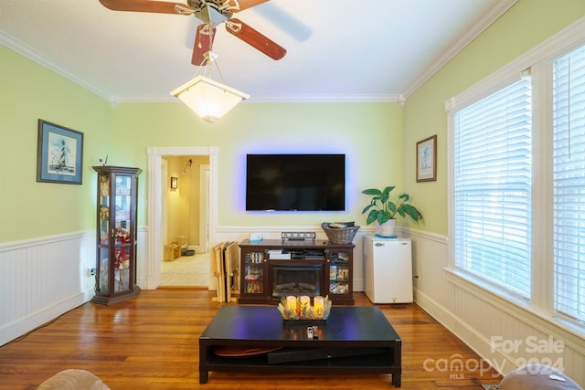 living room featuring hardwood / wood-style flooring, ceiling fan, crown molding, and a wealth of natural light