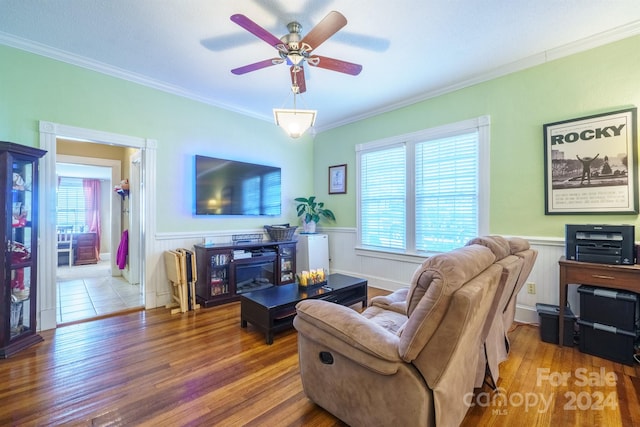 living room with hardwood / wood-style floors, ceiling fan, and ornamental molding