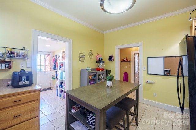 tiled dining room featuring crown molding