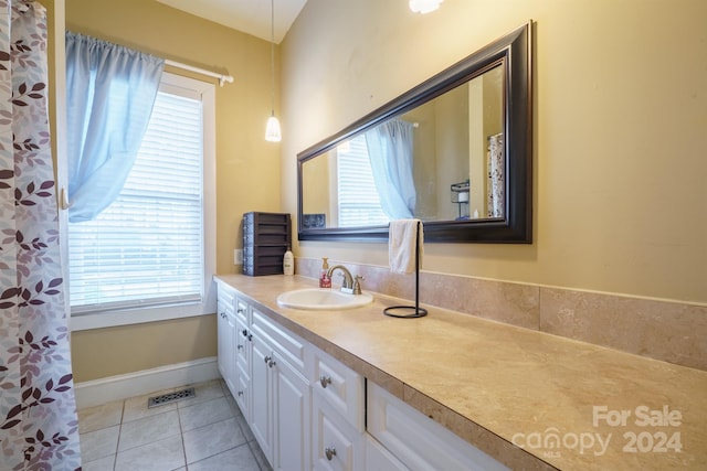 bathroom with tile patterned flooring, vanity, and a wealth of natural light