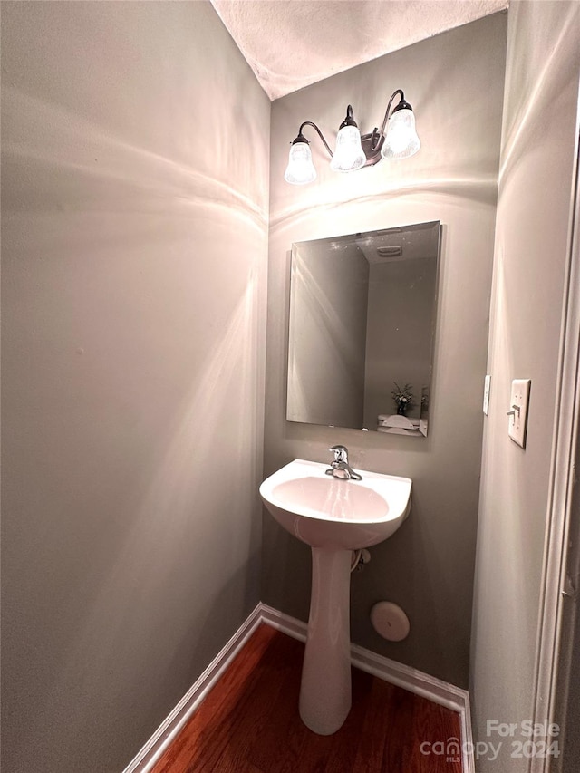 bathroom with hardwood / wood-style floors and a textured ceiling