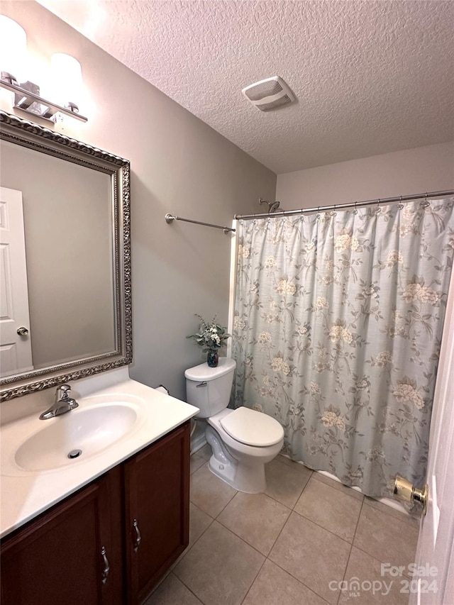 bathroom featuring vanity, a textured ceiling, tile patterned floors, and toilet