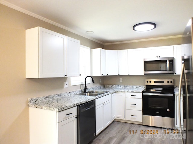 kitchen featuring white cabinets, stainless steel appliances, ornamental molding, and sink