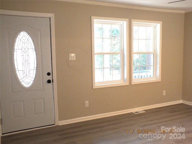 entrance foyer with dark wood-type flooring and crown molding