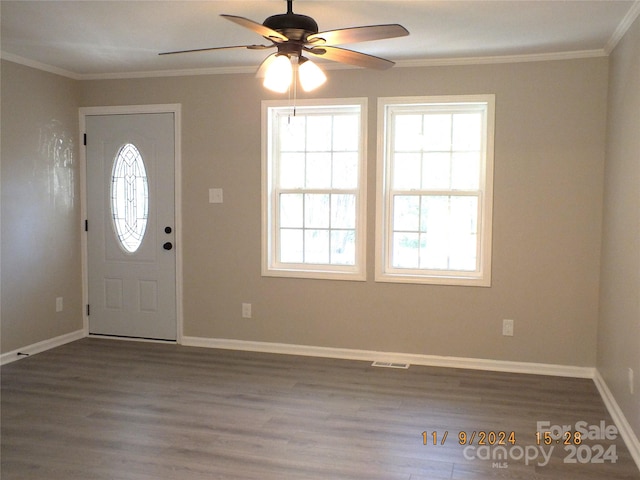 foyer with dark wood-type flooring, ceiling fan, and crown molding