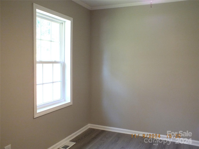 spare room with crown molding and dark hardwood / wood-style flooring