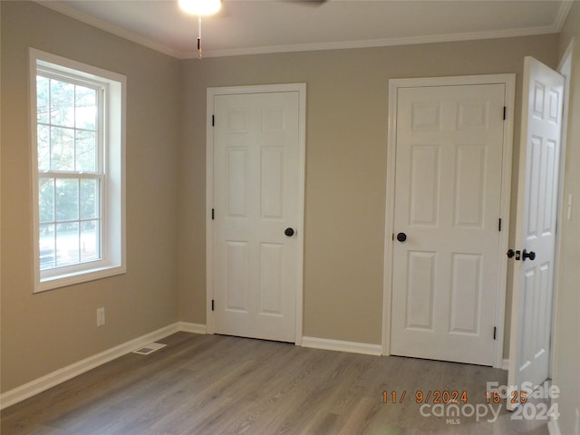 unfurnished bedroom with light hardwood / wood-style floors and crown molding