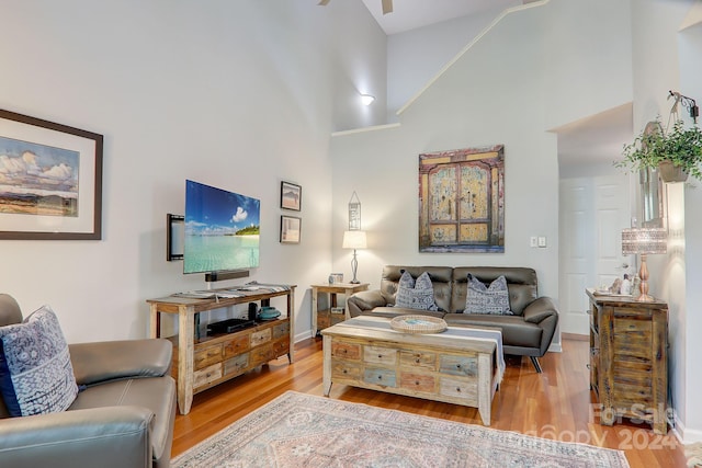 living room with high vaulted ceiling and hardwood / wood-style floors