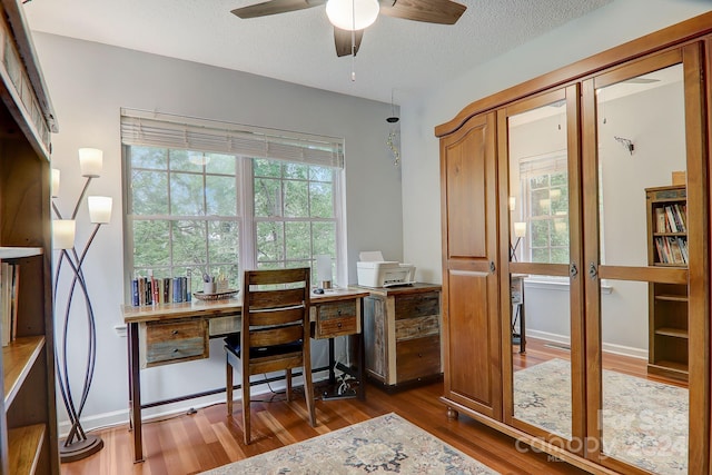 office space with dark wood-type flooring, a textured ceiling, ceiling fan, and plenty of natural light