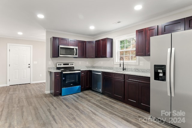 kitchen with stainless steel appliances, sink, light hardwood / wood-style flooring, and crown molding