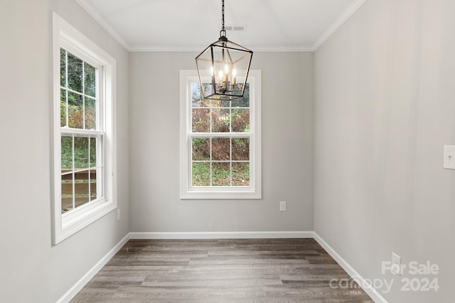 unfurnished dining area featuring hardwood / wood-style floors, a healthy amount of sunlight, and an inviting chandelier