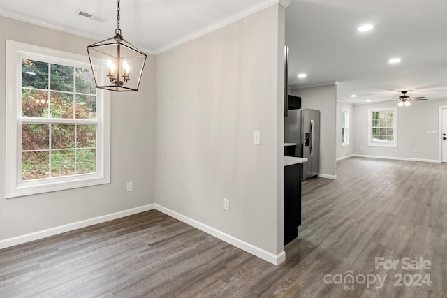 interior space featuring ornamental molding, ceiling fan with notable chandelier, and dark wood-type flooring