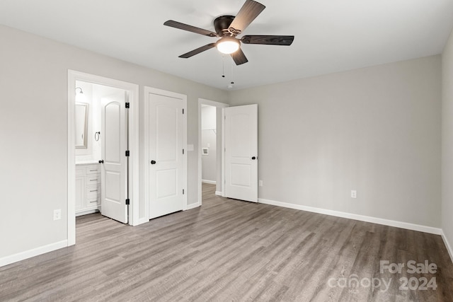 unfurnished bedroom featuring ensuite bathroom, ceiling fan, and light hardwood / wood-style flooring