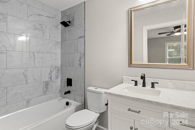 full bathroom featuring tiled shower / bath, vanity, toilet, and ceiling fan