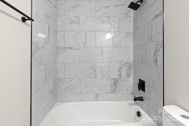 bathroom with tiled shower / bath and toilet