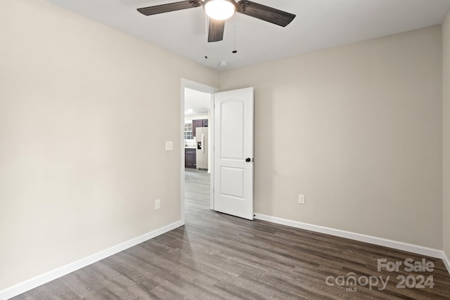 spare room with dark hardwood / wood-style flooring and ceiling fan