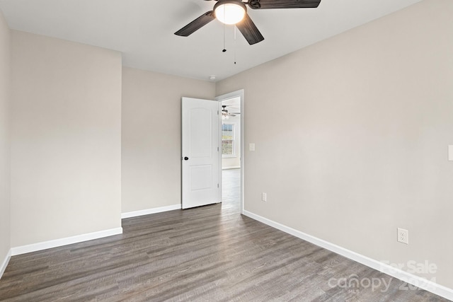 empty room with dark wood-type flooring and ceiling fan