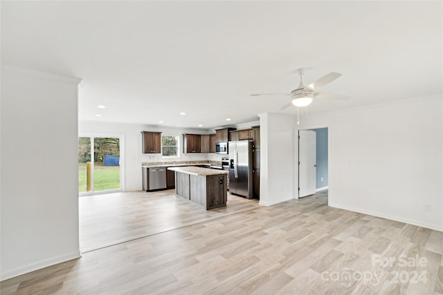 kitchen featuring stainless steel appliances, a center island, ceiling fan, crown molding, and light hardwood / wood-style flooring