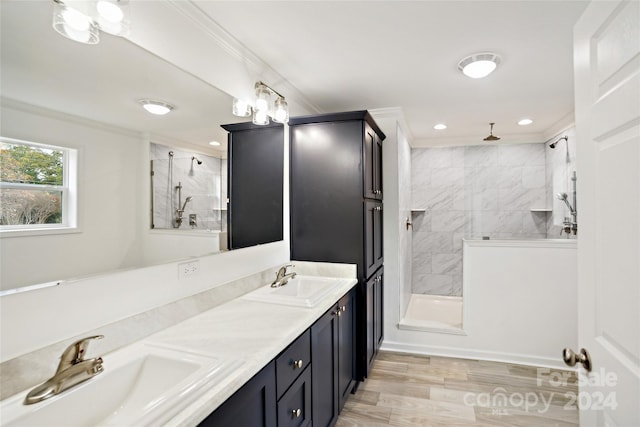 bathroom with wood-type flooring, vanity, tiled shower, and crown molding