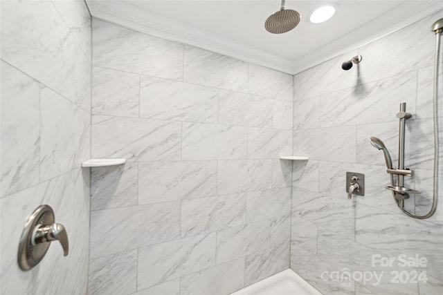 bathroom featuring tiled shower and crown molding