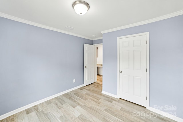 unfurnished bedroom featuring light hardwood / wood-style flooring, crown molding, and a closet