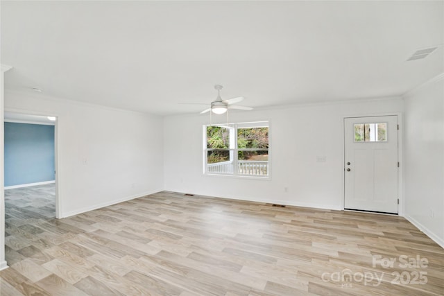 interior space featuring baseboards, a ceiling fan, light wood-style flooring, and crown molding