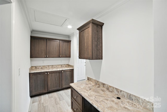 kitchen featuring dark brown cabinets, recessed lighting, light wood-style flooring, and crown molding