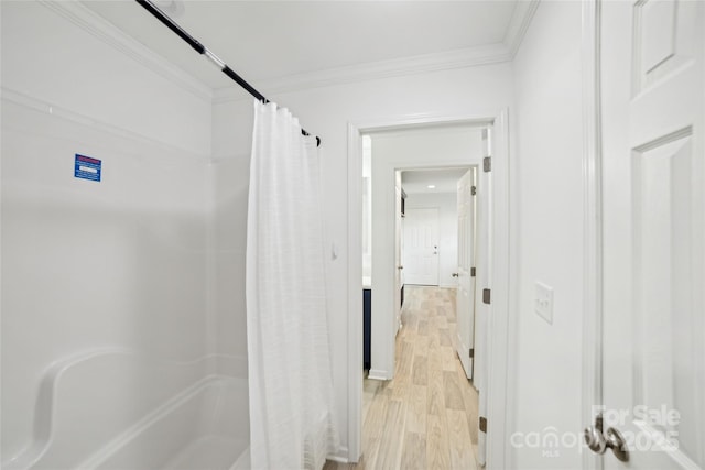 bathroom with curtained shower, ornamental molding, and wood finished floors