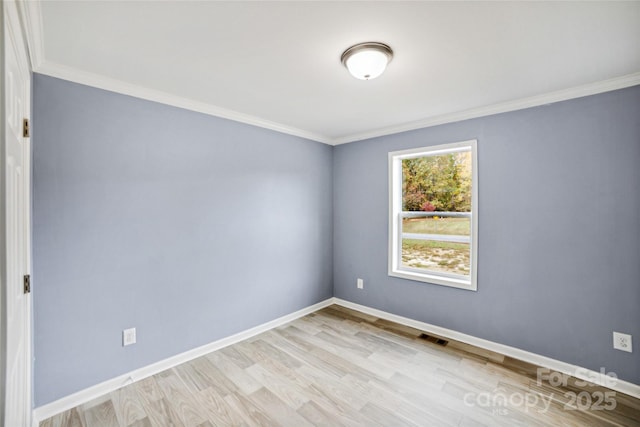 unfurnished room featuring light wood-style floors, visible vents, baseboards, and ornamental molding