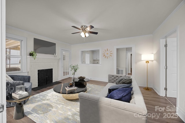 living room featuring a brick fireplace, ceiling fan, ornamental molding, and hardwood / wood-style flooring