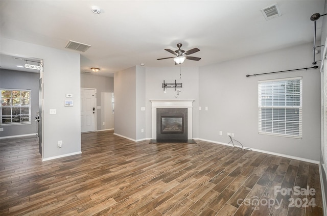 unfurnished living room featuring dark hardwood / wood-style floors and ceiling fan