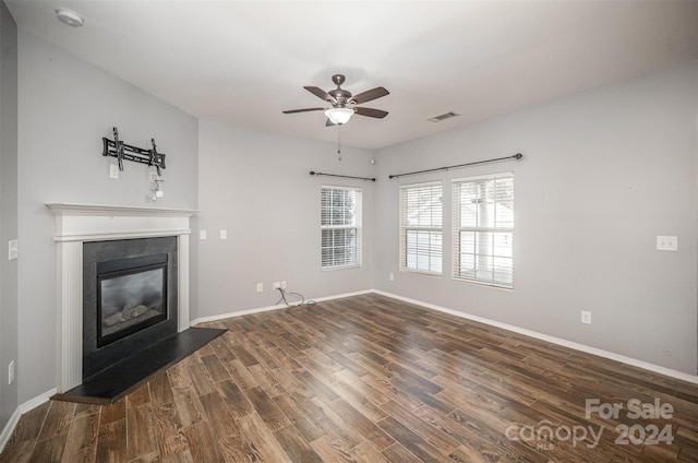 unfurnished living room featuring ceiling fan and dark hardwood / wood-style floors