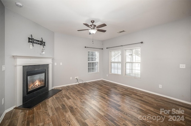 unfurnished living room featuring ceiling fan and dark wood-type flooring