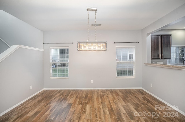 unfurnished dining area with plenty of natural light and dark wood-type flooring