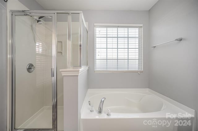 bathroom featuring shower with separate bathtub