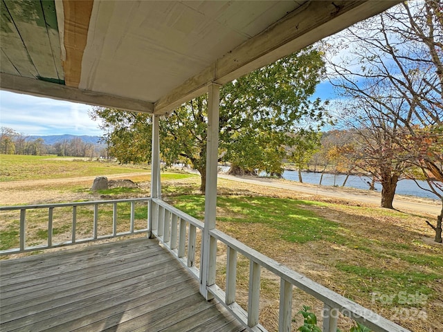 wooden terrace with a water and mountain view