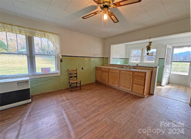 kitchen with light hardwood / wood-style flooring, ceiling fan, sink, and heating unit