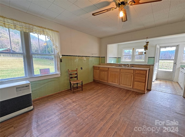 kitchen with light hardwood / wood-style floors, ceiling fan, sink, and heating unit